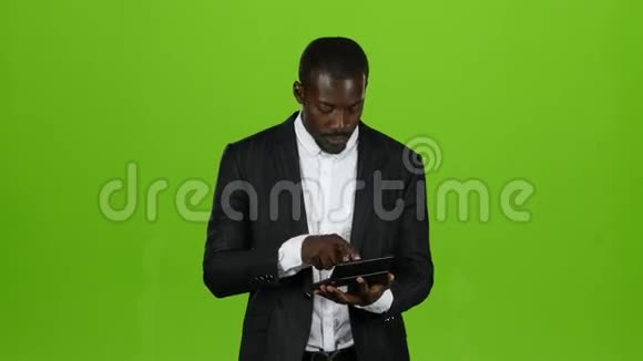 非洲商人用计算器计算他的收入他微笑着绿色屏幕视频的预览图
