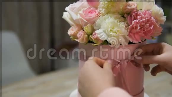 女性的双手用鲜花做花边蝴蝶结视频的预览图