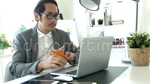 在办公室工作的商务人员在笔记本电脑上工作4K慢动作亚洲商务人员在办公室戴眼镜视频的预览图