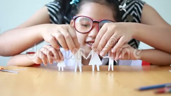 亚洲小女孩在幼儿园统一剪纸家庭形状与母亲视频的预览图