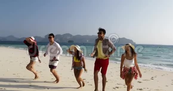 快乐的人们在沙滩上从水中奔跑男女混合成群结队的游客开心地微笑着视频的预览图