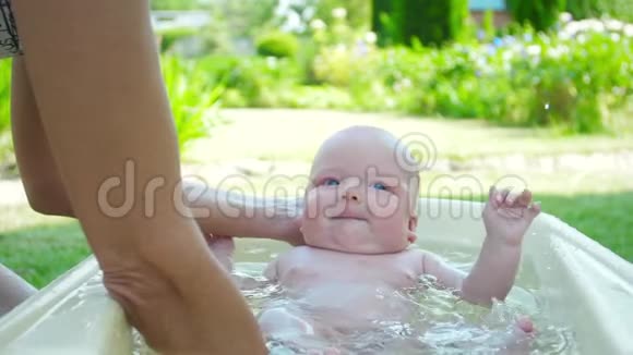 新生婴儿在大自然中洗澡慢动作视频的预览图