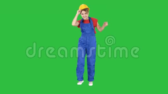 女建筑工人在绿色屏幕上滑稽的舞蹈Chroma键视频的预览图