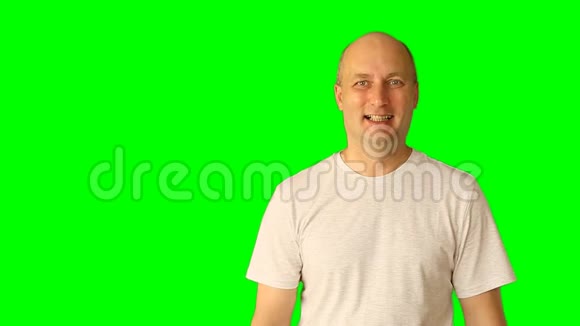 一个笑着的年轻人在绿色屏幕上做手势用手和头做宽笑手势带预乘的夹子视频的预览图