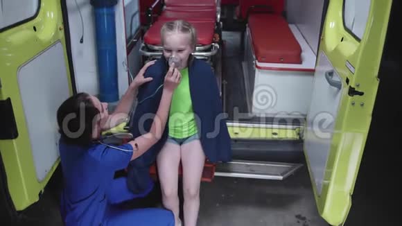 女孩坐着一辆带氧气面罩的救护车视频的预览图