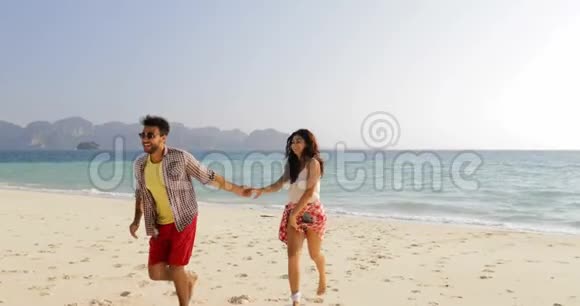 男人引领女人从水中情侣牵着手在沙滩上奔跑快乐的微笑游客拥抱视频的预览图