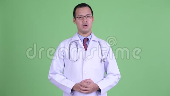 戴眼镜的快乐亚洲男医生在解释视频的预览图