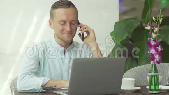 商人在手机上说话用笔记本电脑工作做商务电话会议视频的预览图