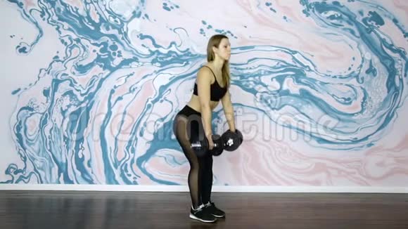 健身教练用哑铃做蹲运动和美丽的女人视频的预览图