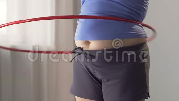 超重年轻女子旋转呼啦圈纤腰锻炼慢动作视频的预览图