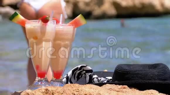 埃及海滩上的热带新鲜果汁帽子和眼镜矗立在红海边的岩石上视频的预览图