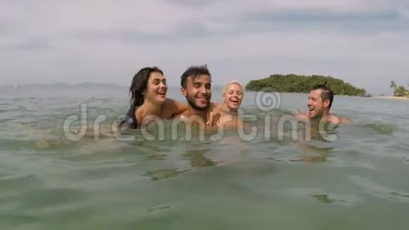 一群快乐的人在海上游泳动作镜头年轻嬉戏的朋友一起在海滩上玩耍视频的预览图