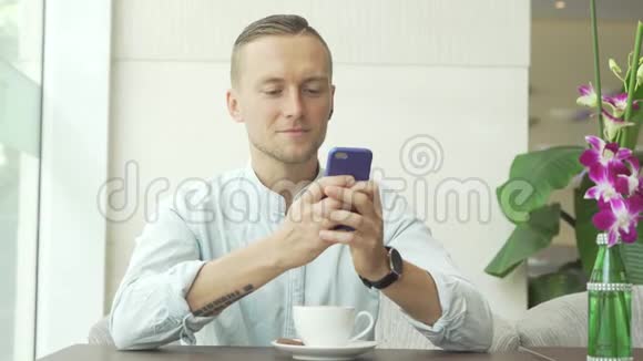 男人用手机笑着喝咖啡视频的预览图