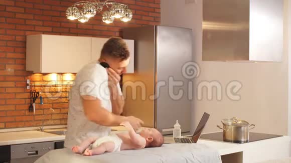 年轻的父亲照顾他的小儿子试图同时做几件事视频的预览图
