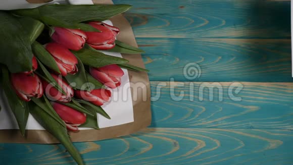 我母亲留言条和郁金香花束在木桌上的俯视图恋爱关系的概念母亲日视频的预览图