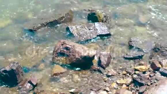 岩石海滩上清澈的海浪石岸背景上透明的海水视频的预览图