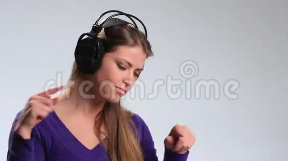 带耳机的可爱女孩听音乐很开心视频的预览图