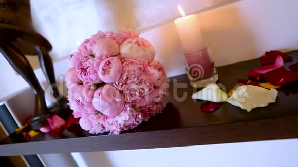 婚礼花束放在桌子上燃烧蜡烛和新娘花束视频的预览图