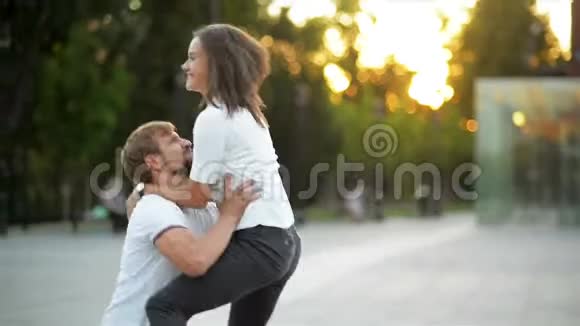 年轻活跃的夫妇在城里一起玩的肖像漂亮的女朋友在男友手上跳视频的预览图