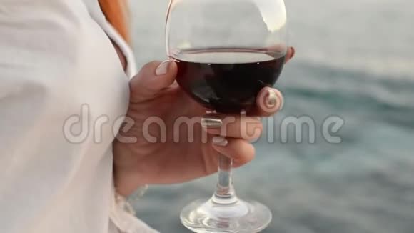 一个女人手里拿着一杯红酒逆着大海视频的预览图