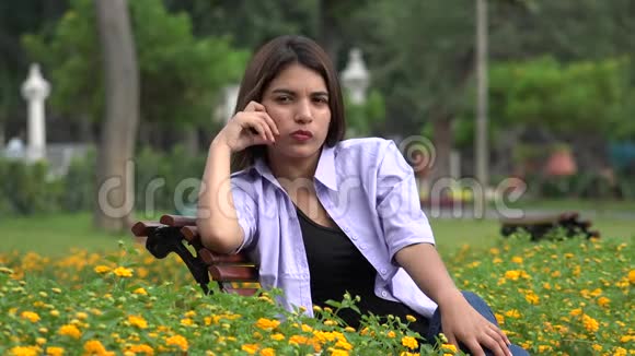 孤独的女孩子坐在公园里视频的预览图