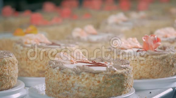 在面包店装饰蛋糕工人在工业糖果中使用奶油装饰蛋糕视频的预览图