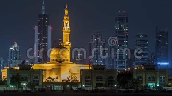 现代迪拜城市天际线随着夜晚拉希德哈代斯清真寺的时间推移水上摩天大楼被照亮视频的预览图