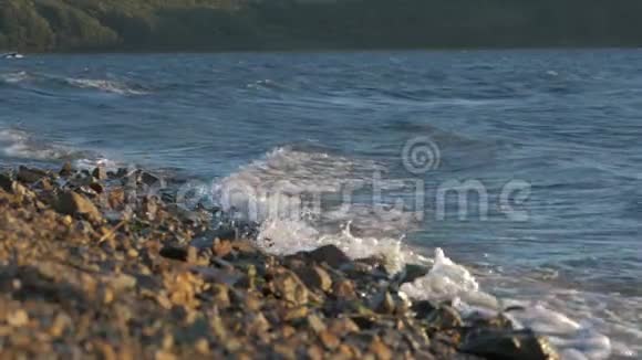夕阳下海浪拍打着海岸上的岩石视频的预览图