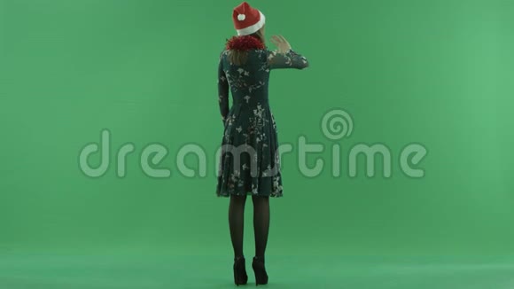 戴圣诞帽的年轻女子在虚拟环境中做手势背景上的色度键视频的预览图