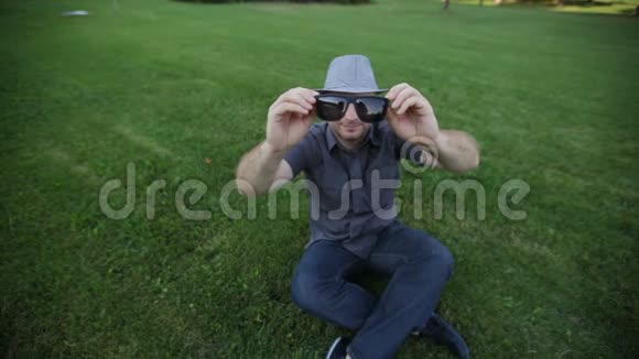 戴帽子的男人在夏日草地上戴太阳镜视频的预览图