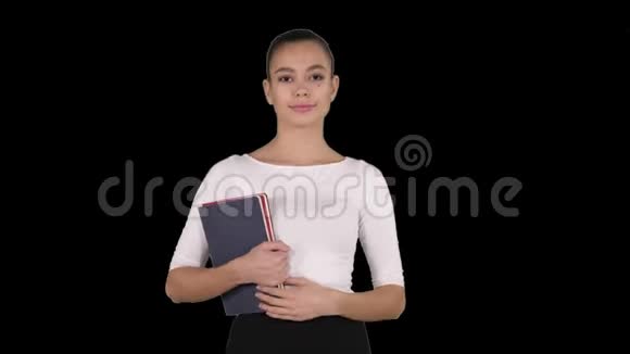美丽的年轻女子带着笔记本行走阿尔法频道视频的预览图