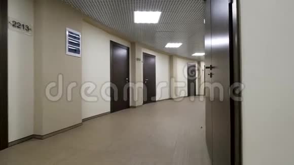 空的圆形的走廊有浅米色的墙壁和封闭的深棕色的门在一条灯火通明的走廊上关闭了门视频的预览图