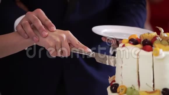 宴会上新娘和新郎切制的白色庆祝蛋糕和水果视频的预览图