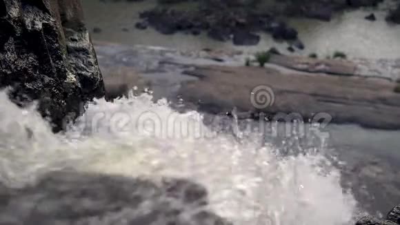 从顶部看到瀑布山石上的近水流视频的预览图