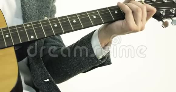 一个男人的特写他的手触摸着吉他上的弦视频的预览图