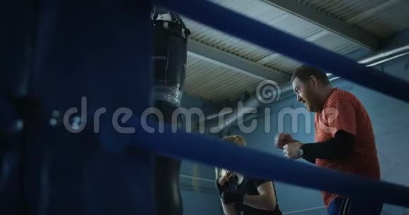 女孩拳击拳击袋与教练视频的预览图