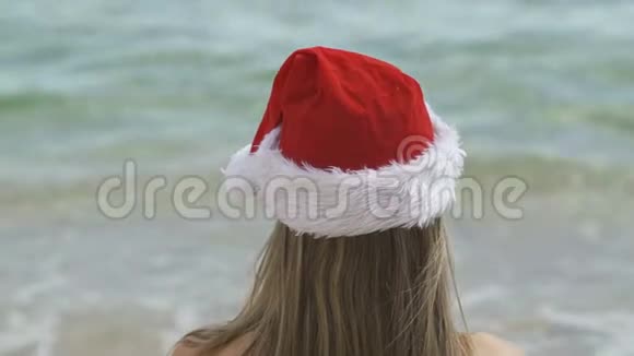 一个年轻的女人坐在沙滩上看着大海视频的预览图
