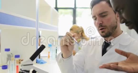 科学家小组在遗传学实验室用显微镜检查植物样本视频的预览图