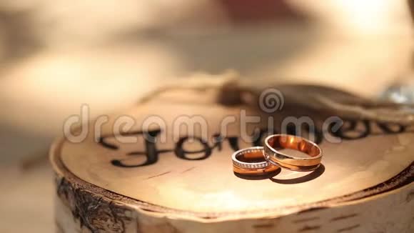结婚戒指躺在树桩上木制的乡村风格铭文永远新郎和新娘的仪式上视频的预览图