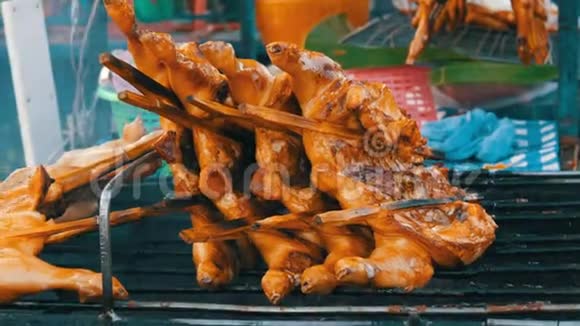 全鸡胴体烤架串在木棒上烤在烤架上泰国街头美食男人双手翻身视频的预览图