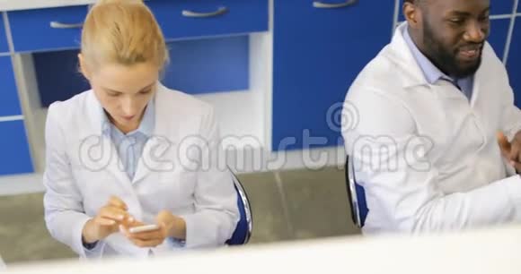 不同的科学家团队在实验室使用手机穿着白衣交谈视频的预览图