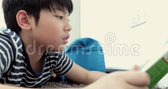 亚洲青少年前在地板上休息阅读卡通书脸要光滑视频的预览图