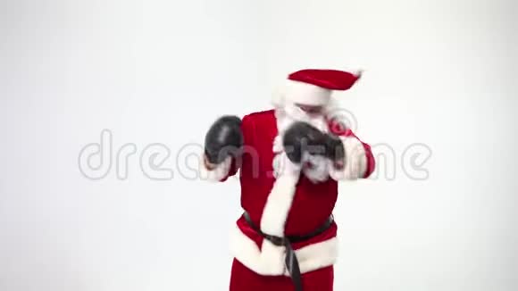 圣诞节白色背景上的圣诞老人戴着黑色拳击手套完成了拳击拳击拳击手视频的预览图