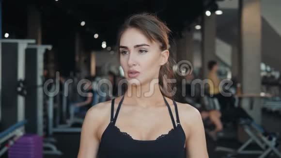 年轻的运动女性在锻炼后在健身房喝水视频的预览图