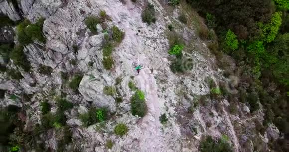 一名山地自行车手在山顶上举起自行车的空中射击视频的预览图