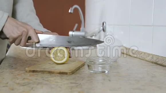 厨房里的木切割板上的女人手切柠檬的特写侧视视频的预览图