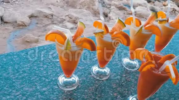 各种新鲜的异国鸡尾酒或果汁玻璃与稻草在海滩酒吧埃及红海视频的预览图