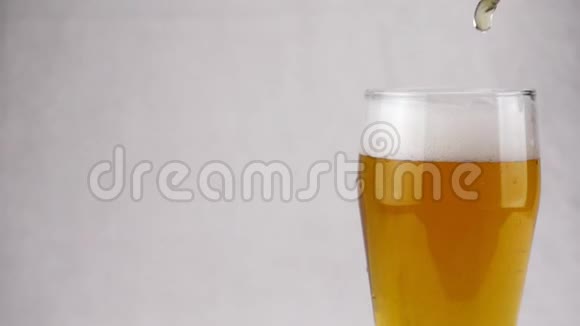 啤酒从顶部涌入玻璃形成泡沫视频的预览图