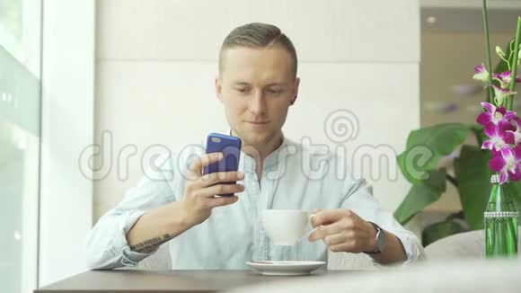 男人在智能手机上讲话喝咖啡视频的预览图