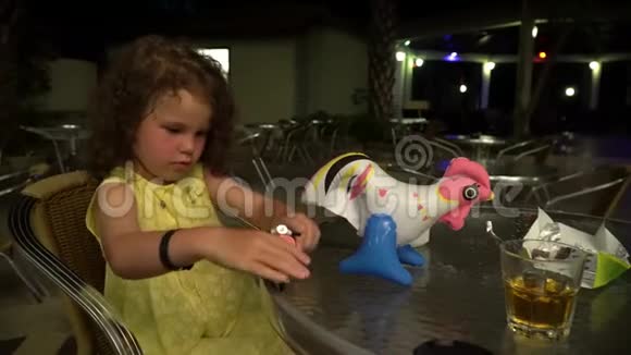 小女孩在夜餐馆的桌旁玩耍视频的预览图
